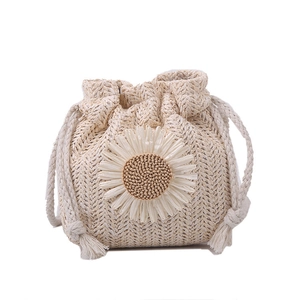 Sac seau tissé beige fait main avec une grande fleur de marguerite blanche et pompons