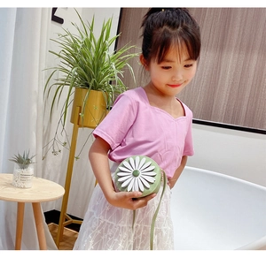 Detail of a round mint green kids crossbody bag with a 3D white daisy floral pattern