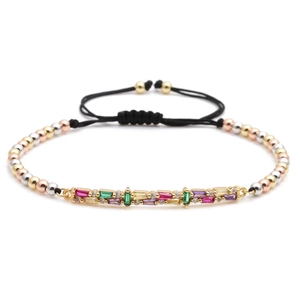 Detail of colorful rectangular gems and tri-color beads on adjustable woven bracelet
