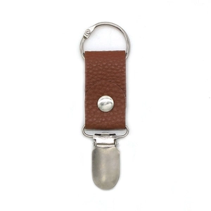 Detail of brown PU leather hat clip for travel bag with silver metal ring and clasp