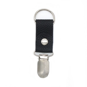 Macro view of black pebble leather hat clip with silver metal ring and grip for travel
