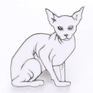 Dettaglio di una spilla smaltata a forma di gatto bianco con bordi argentati