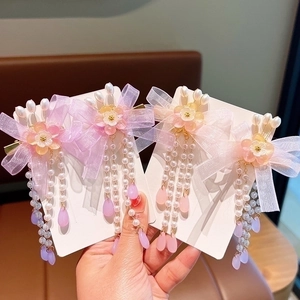 Pink and purple bow hair clips with floral accents and pearl tassels for girls