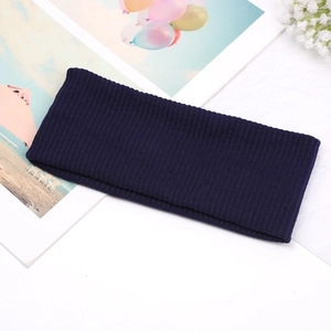 Detail of dark blue ribbed knit headband texture with decorative magazine and dried flowers
