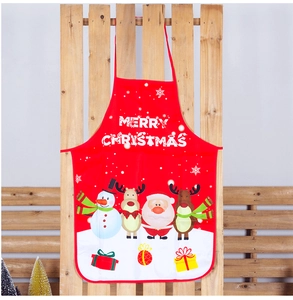 Detail of red Christmas apron featuring Merry Christmas text and festive cartoon patterns