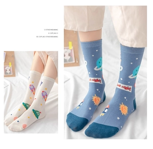 Detail of space-themed cotton crew socks with rocket and planet patterns in cream and blue