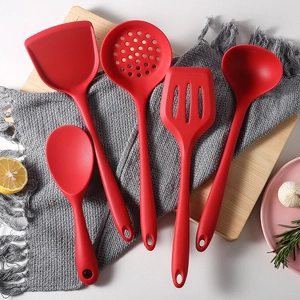 5-piece red silicone kitchen utensil set with spatula and spoon on a wooden board