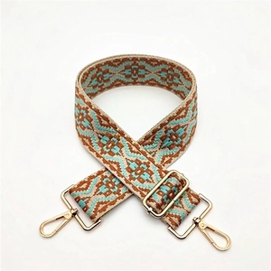 Close-up of ethnic geometric pattern strap with golden metal hooks and adjustable buckle