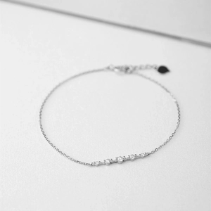 Pulsera minimalista de oro blanco de 18K con cinco diamantes en una cadena fina