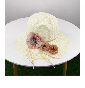 Women straw sun hat with large brim and pink floral accents for beach vacations