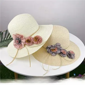 Detailed close-up of straw sun hats featuring woven texture and chiffon flower accents