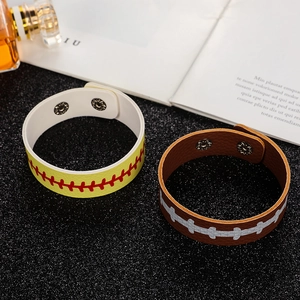 Detail of sports-themed PU leather bracelets with baseball and rugby stitching and metal snaps