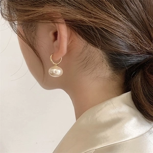 Elegant gold pearl hoop earrings shown on model for a minimalist French style look