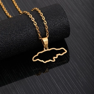 Detailed view of golden Jamaica map pendant necklace on professional black jewelry display