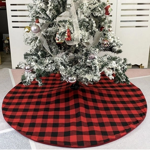 Close-up of red and black buffalo plaid Christmas tree skirt on snowy tree base