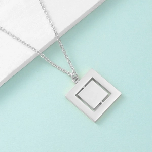 Macro shot of silver rotating geometric square pendant on stainless steel necklace