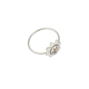 Detailed close-up of a silver stainless steel ring with white flower design element