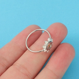 Close-up of a silver stainless steel mustard seed ring with white enamel daisy flower