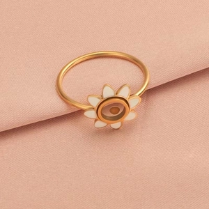 Minimalist stainless steel mustard seed ring with yellow sunflower design on fabric