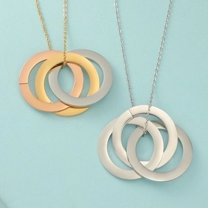 Detail of three-color interlocking rings necklace in rose gold, gold, and silver finishes