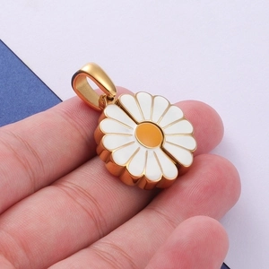 Macro shot of a handmade golden sunflower daisy charm with white petals and orange center