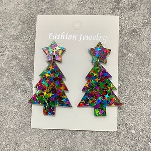 Detail of Christmas tree earrings with colorful glitter stars on acrylic material