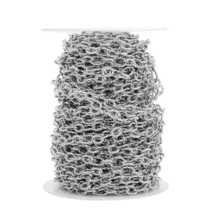 Detailed macro view of 7mm silver stainless steel twisted link chain on a white spool