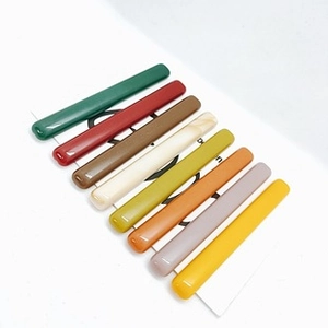 Détail de 8 barrettes colorées en acrylique avec finition brillante sur carte blanche