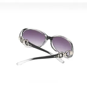 Close-up of oversized sunglasses featuring gradient purple lenses and metal horsebit detail