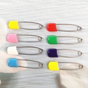 Vista dettagliata di otto spille di sicurezza colorate per bambini con testa in plastica