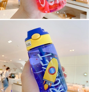 Detail of colorful kids plastic water bottles with astronaut motifs and straw lids