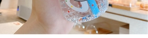 Close-up of a hand holding a transparent cartoon plastic water bottle with blue straw