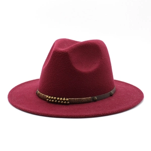 Detail of burgundy wool fedora hat featuring brown leather band with gold rivets