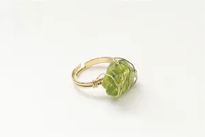 Detailed view of handmade gold wire-wrapped ring with raw green natural stone