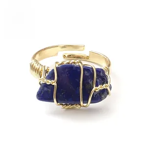 Close-up of handmade wire-wrapped ring with irregular lapis lazuli and adjustable gold band