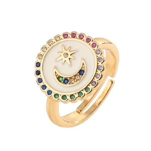 Adjustable gold ring with celestial star and moon motifs on a white shell-style disc