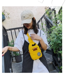 Outdoor lifestyle shot of a cute yellow duck canvas crossbody bag worn by a model