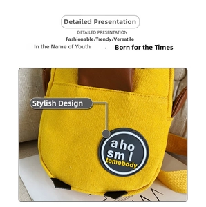 Close-up of yellow canvas bag featuring a circular rubber logo patch and durable texture