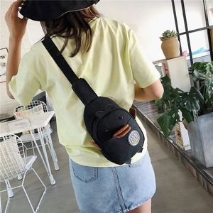 Detailed back view of a black 3D cartoon duck canvas crossbody bag worn by a model