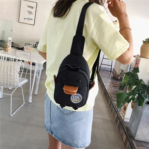 Close-up of black penguin canvas crossbody bag showing 3D wings and feet details