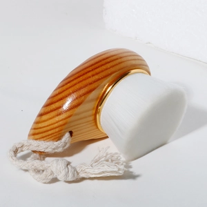 Detail of wooden facial brush with soft white bristles and natural cotton hanging rope