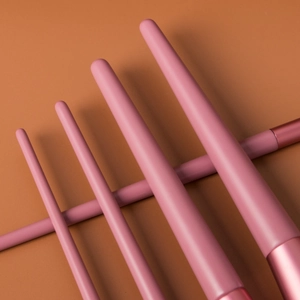 Close-up of pink makeup brush handles with professional smooth texture and sleek finish