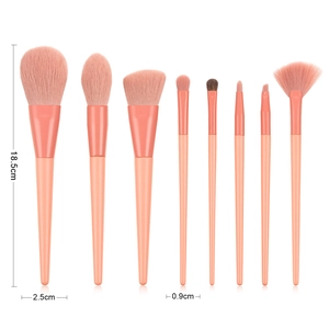 Detail view of 8 coral pink makeup brushes with size dimensions on white background