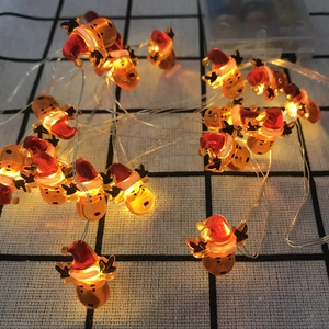Detailed view of reindeer LED string lights with warm yellow glow on checkered cloth