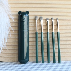Detailed view of 5-piece makeup brush set with dark green bear storage holder
