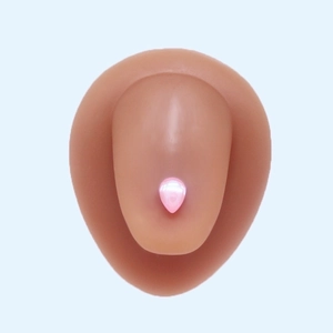 Detail showing a pink teardrop-shaped crystal tongue stud with a polished steel base