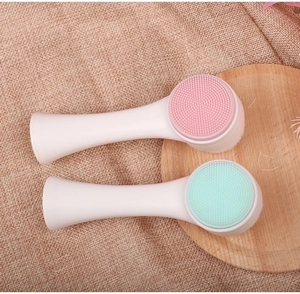 Dettaglio delle spazzole viso in silicone rosa e verde menta con manici bianchi