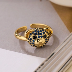 Detailed macro view of an adjustable gold bear ring encrusted with blue and black stones