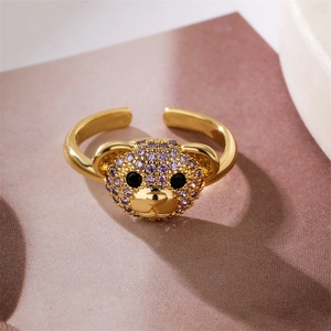 Macro shot of an adjustable gold ring featuring a 3D bear head with purple zircons