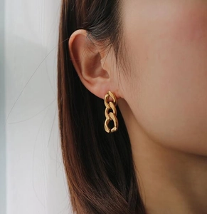 Detailed view of 18K gold plated chunky chain hoop earrings worn on a female model